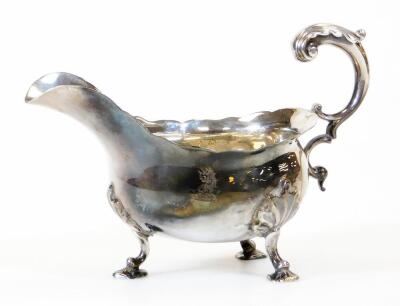 A George III silver sauce boat, with flared rim, flying acanthus scroll handle and leaf capped triple hoof feet, probably London 1768, 12cm high, 6.5oz.