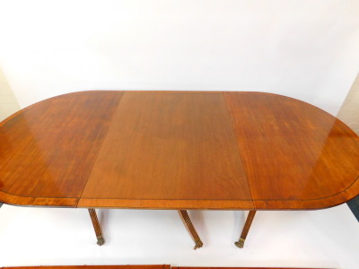 A reproduction Regency mahogany triple pedestal dining table, with one large and two smaller additional leaves, raised on turned columns and fluted outswept legs, brass capped on castors, 72cm high, 146cm wide, 272cm extended, 106cm deep. - 2