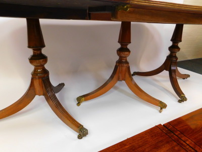 A reproduction Regency mahogany triple pedestal dining table, with one large and two smaller additional leaves, raised on turned columns and fluted outswept legs, brass capped on castors, 72cm high, 146cm wide, 272cm extended, 106cm deep. - 3