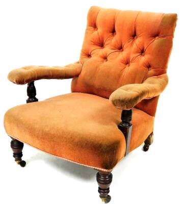 A late 19thC low armchair, with studded back and arms and overstuffed seat in peach material, with turned arm supports and turned front legs terminating in castors, in the manner of Howard but unmarked, 79cm high.