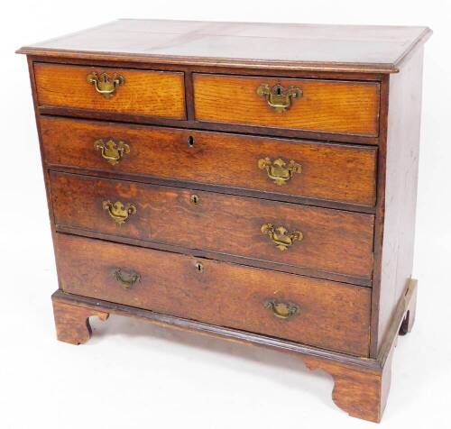 An 18thC oak chest, of two short and three long graduated cock beaded drawers, each with swan neck plate back handles on ogee bracket feet, 93cm high, 104cm wide, 52cm deep.