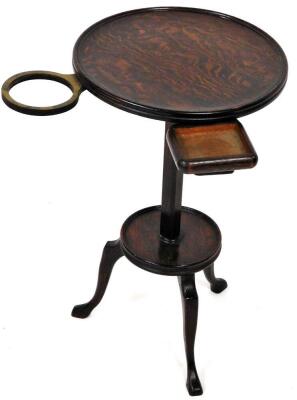 A 1920's oak drinks stand, the circular top with an articulated pull out section rotating on a circular fixed base, terminating in triple shaped legs, 54cm high, the top 32cm diameter.