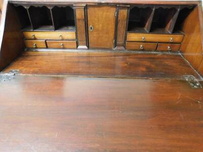 An 18thC mahogany bureau, the plain fall with oval lock revealing a fitted interior with central cupboard flanked by columns, pigeon holes and various drawers, above four long graduated drawers, with elaborate swan neck handles on ogee bracket feet, 107cm - 2