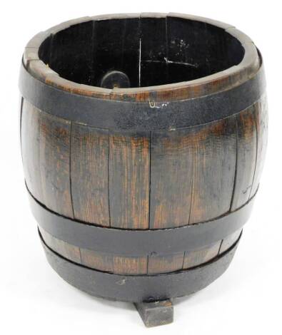 A stained oak coopered barrel, with double metal banding on shaped feet, probably 20thC, 45cm high, 44cm diameter.