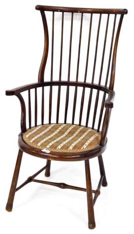 A West Country style stick back high back Windsor style chair, with a shaped cresting rail and scroll arm, with overstuffed petit point embroidery on tapering front legs, joined by a H stretcher, 110cm high.