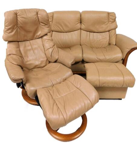 A modern Stressless lounge suite, comprising two seater leather settee with a lightwood frame, in cream, 92cm high, 170cm wide, 102cm deep, swivel armchair and footstool.