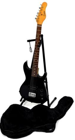 An Encore six string electric guitar, in black colour way, 99cm high, with canvas case and stand.