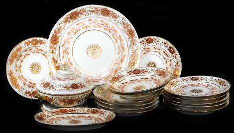 An English semi porcelain part dinner service, in red and gilt floral pattern, comprising serving plate, 33cm diameter, lidded tureen, oval plate, two soup bowls and twelve dinner plates, some incised marks beneath. (a quantity)