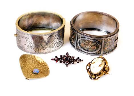 A chased bangle, of oval form, with plain clasp, unmarked, 7cm wide, and another with panels of flowers in bicolour metal, initialled (2), a shaped cameo brooch set with a figure quarter profile, Arts and Crafts hammered brooch, set with oval stone sectio