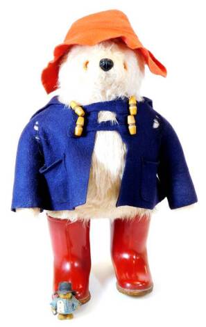 A mid 20thC Paddington Bear plush jointed teddy bear, in blue duffle coat with red hat and red Dunlop Wellington boots, 50cm high.