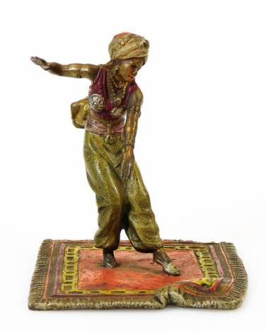 A 20thC cold cast bronze figure, in the manner of Bergmann of an Eastern figure in flowing robes on a carpet in colours, unmarked, 10cm high.