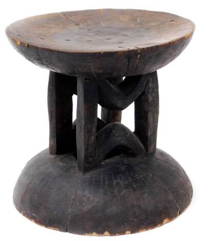 A 19thC African tribal stand or headrest, with circular dish top on a vertical stem and domed foot, 24cm high, 25cm diameter.