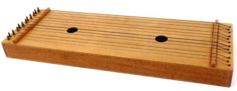 An oak zither, of rectangular form with two central holes, with twelve strings, 58cm wide.