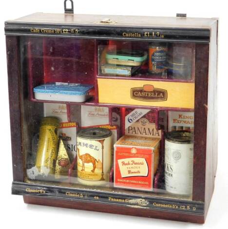 An advertising retailer's table display cabinet, with front opening marked cafe creme, partially ebonised set with a range of various smoking accessories, camel blend cigarettes, tin, various other tins, cigar boxes, etc., 27cm high, 30cm wide, 18cm deep.