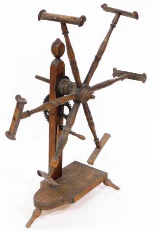 A late 19thC oak and elm wool winder, with six spokes on a shaped base, terminating in triple shaped feet, 100cm high.