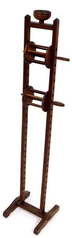 An unusual oak reel or wool winder, with two sections with open dish top, partially articulated with a pierced stem on scroll feet, 104cm high.