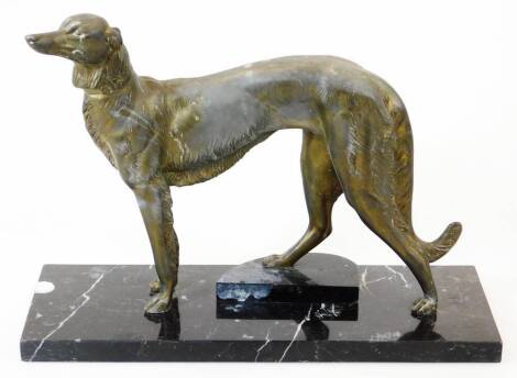 A 20thC bronze finish figure of a standing lurcher, on a marble finish base, with right leg on a stepped semi circle section, probably spelter, 29cm high.