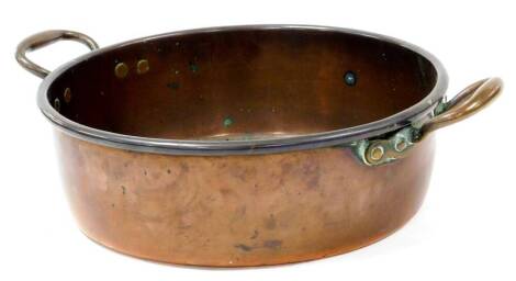 An early 20thC copper bowl, of circular form with fixed handles, 53cm wide.