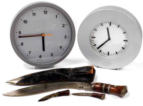 An early 20thC Kukri and scabbard, with a shaped blade and turned wooden handle with double metal and orb decoration, 47cm wide, a Habitat wall clock, and another similar unmarked. (a quantity)