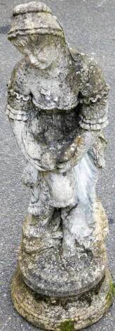 A late 20thC stone classical statue, formed as a lady in flowing robes, holding bird, on stepped base, 88cm high.