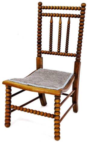 A late 19thC bobbin turned side chair, with shaped back and overstuffed seat on turned front legs, 82cm high.