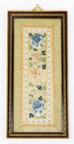 An early 20thC Chinese silk work, of rectangular form, set with flowers with an outer floral border, glazed and framed, 51cm x 23cm.