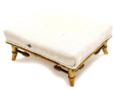 An early 20thC Aesthetic style bamboo overstuffed foot stool, of rectangular form, in floral cream material, on splayed legs, with elaborate buttress supports, 13cm high, 29cm wide, 25cm deep.