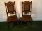 A pair of Edwardian carved oak hall chairs