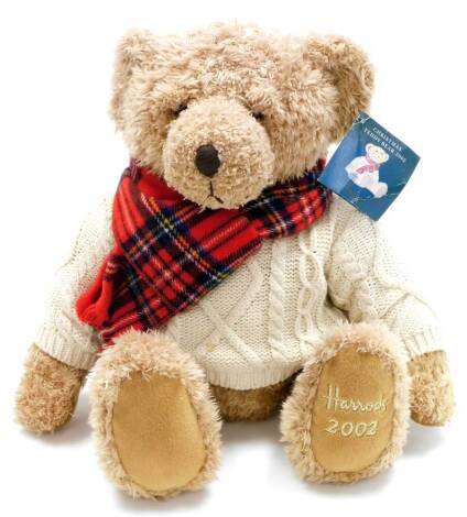 A Harrods plush jointed 2002 teddy bear, wearing tartan scarf and cream jumper, with label to the ear, 45cm high.