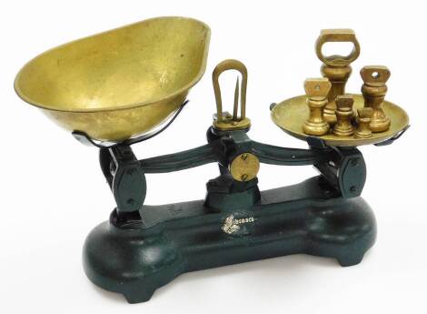 A 20thC Ibrasco table top scale, with brass pans and weights, the base in green, 24cm, high.