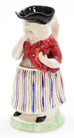 An early 19thC female snuff taker Toby Jug, in standing pose, polychrome decorated with a striped skirt, pink waistcoat and black tricorn hat, on a sponge base, Portobello style, circa 1840, Harland collection number 65 label, various other Sotheby's and 