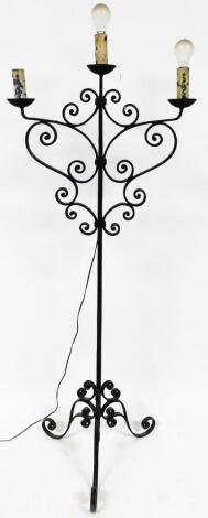 A 20thC wrought iron three branch lamp standard, on square stem terminating in triple scroll feet, 180cm high.