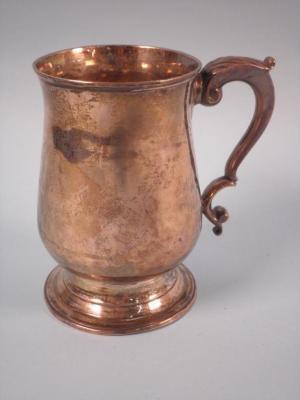 A George III silver mug of baluster form with a scroll handle and domed