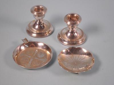 Two silver ashtrays and a pair of small candlesticks (loaded