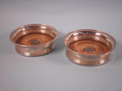 A pair of silver wine coasters