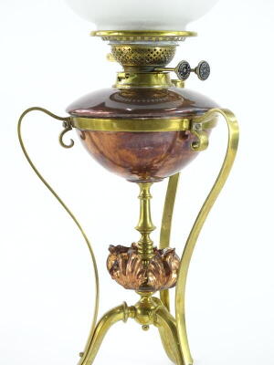 A late 19th/early 20thC copper and brass Arts and Crafts oil lamp, in the manner of W.A.S. Benson, the part frosted shade decorated with flowers, etc., the fitting stamped T.Rowatt and Sons, on shaped supports with central flower head, the base, 41cm high - 2