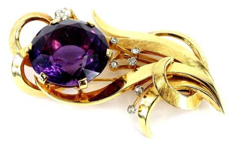 An amethyst and diamond spray brooch, set with single large amethyst 25mm x 15mm, in six claw setting, with spray of tiny diamonds, six tiny illustion set to base and one larger old cut stone to top right, 3.2mm x 2.8mm, approx 0.10cts, in a yellow metal 