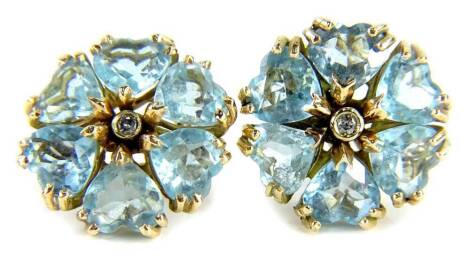 A pair of aquamarine and diamond earrings, each set in a floral cluster with central diamond approx 0.05cts, in rub over platinum setting, surrounded by six heart cut aquamarines each in two point triple claw setting, on a yellow metal pin and clip backin