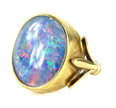 A 9ct gold opal dress ring, with opal doublet, in a rub over gold setting, with three splayed shoulders, on a cut band, 5.2g all in. (opal AF to rear)