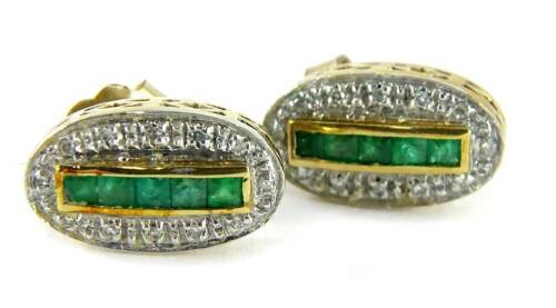 A pair of emerald and diamond earrings, each set with five square cut emeralds, surrounded by illusion set tiny diamonds, in a yellow metal setting, unmarked, with butterfly backs, 3g all in. (AF -pins bent)