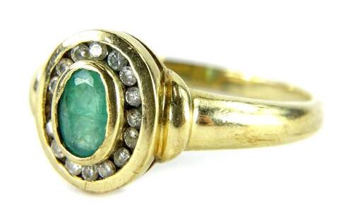 A 9ct gold emerald and diamond dress ring, set with oval cut emerald in rub over setting, surrounded by tiny diamonds (some missing), on a plain band, ring size N½, 2.6g all in.