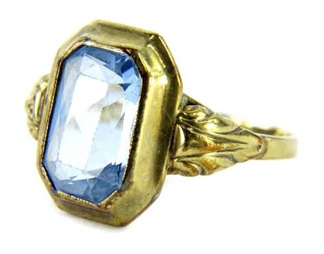 An aquamarine set signet ring, with single rectangular cut stone, on layered setting, with scroll and leaf framed shoulders, yellow metal, marked 333, ring size P, 2.9g all in.