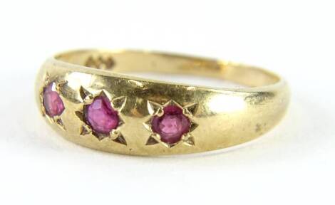 A 9ct gold dress ring, set with three illusion set garnets, ring size P, 2g all in.