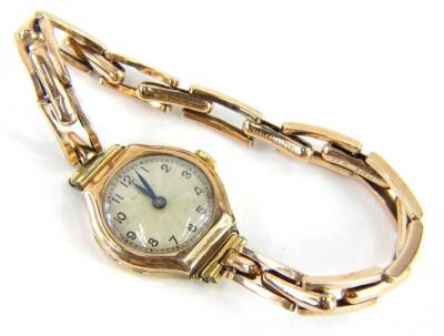 A ladies cocktail watch, with small silvered dial, in a yellow metal casing, on expanding yellow metal strap, marked 9ct, 16g all in.