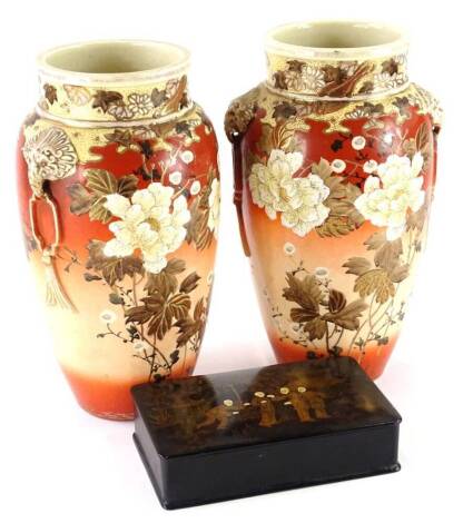 A pair of Japanese Earthenware vases, each decorated with flowers on a mottled coral coloured ground, with gilt handles, and a black oriental style papiermache box. (3)