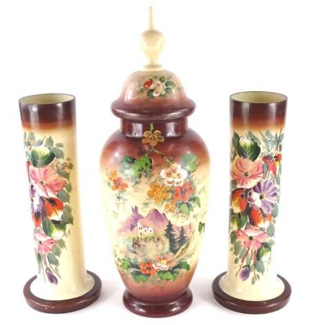 A pair of Victorian cylindrical opaque glass vases, each decorated with flowers and similar vase and cover decorated with a coastal scene, 54cm high.