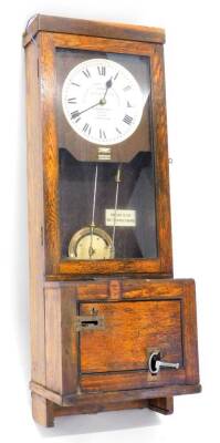 A Gledhill-Brook time recorder, the white painted dial with Arabic numerals in oak case with lockable lower section, keys etc, 114cm high, 40cm wide.