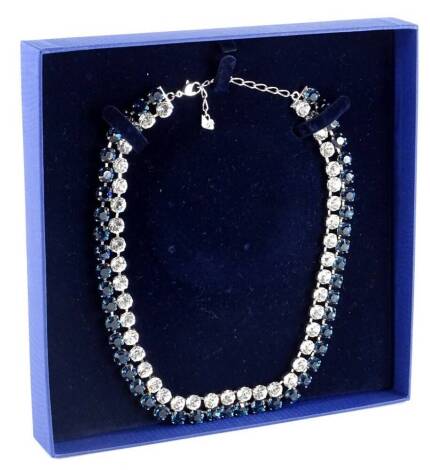 A two row Swarovski crystal necklace, set with row of blue and white crystals, in a white coloured setting, numbered 1062660, 39cm long, boxed.