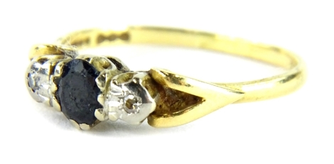 An 18ct gold sapphire and diamond dress ring, with oval cut sapphire flanked by two illusion set diamonds, with V splayed shoulders, ring size Q, 3g all in.