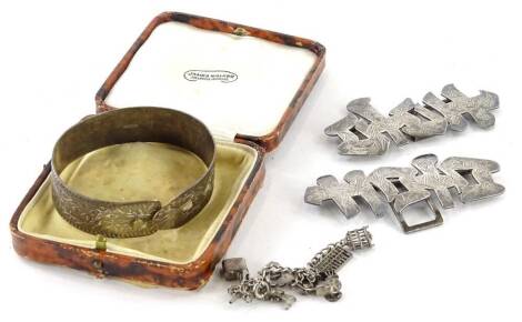 A small quantity of silver jewellery, comprising a Chinese writing and florally engraved belt buckle, a silver charm bracelet and a silver bangle.